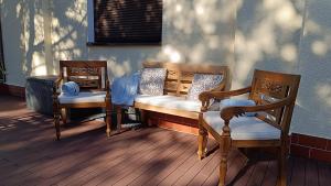 two chairs and a bench on a porch at Zacisze Stasia Ustroń in Nierodzim