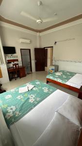 a bedroom with two beds and a piano in a room at Khách sạn Nhất Phương 2 in Ấp Ðông An (1) +8 photos