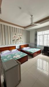 a bedroom with two beds and a couch at Khách sạn Nhất Phương 2 in Ấp Ðông An (1)