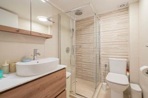 a bathroom with a toilet and a sink and a shower at Thanos and Sofia by RentalsPro - Dionisou Halkidiki in Paralia Dionysiou