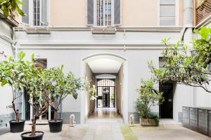 an entrance to a white building with trees at Easylife - Appartamento di Design in Milan