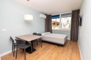 a room with a bed and a table and chairs at Acogedor estudio cala romana in Tarragona +8 photos