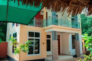 a house with a balcony on the side of it at Hopeland Villas in Msaranga