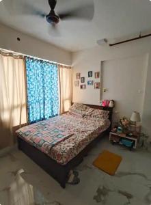 a bedroom with a bed and a window at Sunny Urban Retreat in Mumbai