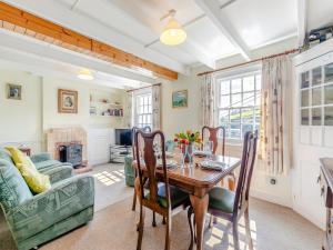 a dining room with a table and a couch at Memory Cottage in Mevagissey