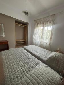 a bedroom with a large bed and a window at Lily's Guest House in Megali Ammos +16 photos
