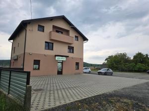 a building with two cars parked in a parking lot at Skitnica U Prolazu in Koprivnica