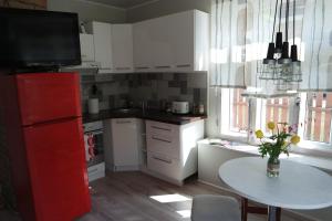 Il comprend une cuisine équipée d'un réfrigérateur rouge et d'une table. dans l'établissement Oakcorner Place Apartment, à Haapsalu