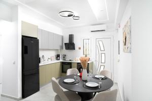 cocina con mesa, sillas y nevera negra en Lunar Dream, en Kalamaki