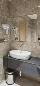 a bathroom with a sink and a mirror at Hotel Skyro Inn in Gandhinagar