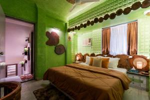 a bedroom with green walls and a large bed at Soho Nest 4-Bedrooms Spacez Wooden House in Mumbai