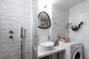 a bathroom with a sink and a shower with a mirror at heliaia2 in Naxos Chora