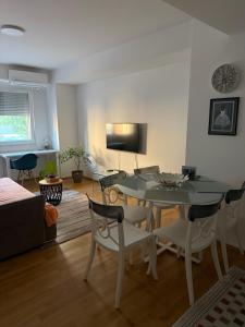 ein Wohnzimmer mit Tisch und Stühlen und einem Fernseher in der Unterkunft ViA prime central location in Ohrid