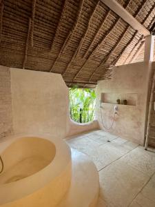a bathroom with a bath tub and a shower at La Cabane in Jimbaran