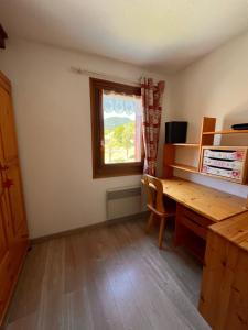 an empty room with a desk and a window at Appartement Duplex in Habère-Poche