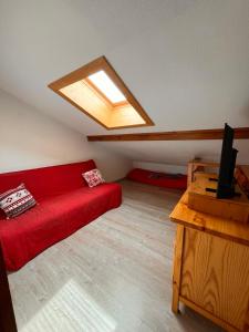 a living room with a red couch and a skylight at Appartement Duplex in Habère-Poche