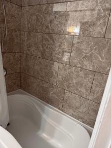 a bath tub in a bathroom with a tile wall at The Comfort Pearl in Topsail +20 photos
