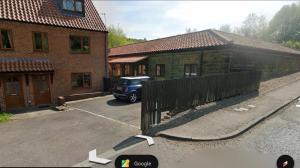 a car parked in a parking lot next to a building at 1 Kilton Mill in Carlin How