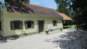 a yellow house with a white bench in front of it at Gara Cottage Private escape with modern comfort and spacious covered terrace in Garabonc