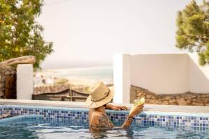 a woman in a hat sitting in a swimming pool at Villa Sahel Bleu in Essaouira