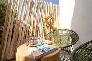 a table with a book and two chairs and a fence at Villa Sahel Bleu in Essaouira +22 photos