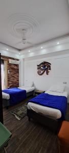 a bedroom with two beds with blue sheets at Egypt Soul hotel retreat in Luxor