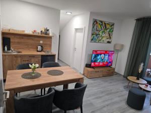 a living room with a dining table and a tv at Skitnica U Prolazu in Koprivnica