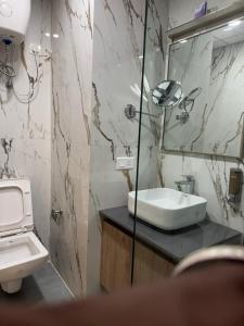a bathroom with a sink and a toilet and a mirror at Sun twilight studio in Greater Noida
