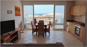 a kitchen and dining room with a table and a television at Pandora Ocena View II in Sal Rei
