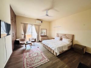 イスラマバードにあるFamily Luxury Lodgesのベッドと椅子とテーブルのある寝室