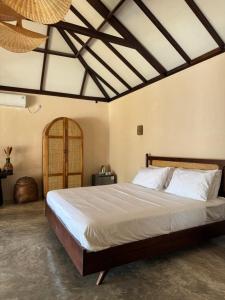 a bedroom with a large bed in a room at NIRA Surf Villas in Maluk
