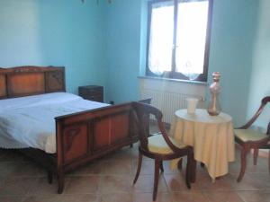 1 dormitorio con 1 cama, 2 sillas y mesa en Ospitalità rurale La Svizzera, en Agliè