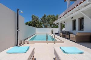 a swimming pool in the backyard of a house at Arokaria Holiday Houses in Platanes