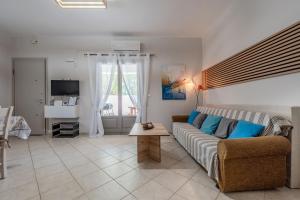 a living room with a couch and a table at Arokaria Holiday Houses in Platanes +42 photos