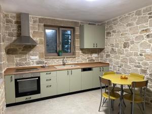 Una cocina con gabinetes blancos y una mesa amarilla. en Casa Maria, en Gramvousá