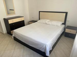 ドゥラスにあるApartment Leonのベッドとドレッサーと鏡のある寝室