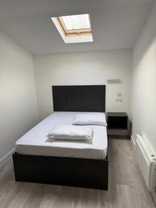 a bedroom with a bed with a black headboard and a window at Sahota B&B in Rotherham +13 photos