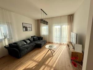 a living room with a black couch and a table at Nexus apartman in Siófok