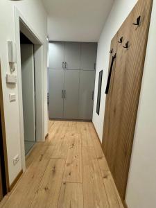 an empty hallway with cabinets and a wooden floor at Nexus apartman in Siófok +9 photos