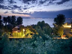 a house on the shore of a lake at night at Nexus apartman in Siófok