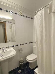 a white bathroom with a toilet and a sink at Ukino Terrace Algarve Concept in Armação de Pêra