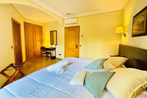 a large white bed in a bedroom with yellow walls at Hotel Punta me Torreblanca Palace in Guadarrama
