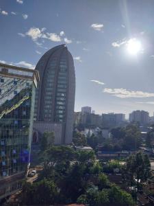 a tall building in front of a city at Modern 1 bedroom in the middle of Kilimani in Nairobi