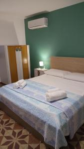 a bedroom with a large bed with towels on it at Appartamento Via Filippini in Reggio Calabria