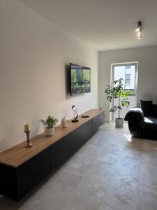 a living room with a couch and a tv on the wall at Apartamenty Cegielnia 1 Lux-Haus in Gorzów Wielkopolski