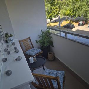 a balcony with two chairs and a table and a window at Apartman Rita in Livno