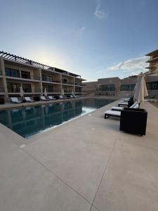 a swimming pool with lounge chairs and a hotel at Family-Friendly Oceanview Retreat Resort Access in Cabo San Lucas