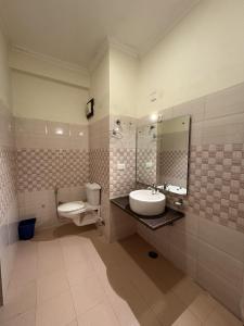 a bathroom with a sink and a toilet and a mirror at Kasauli View Resort # Parking # lift # Garden # Restaurant # Open Terrace # On Road Location in Kasauli +35 photos