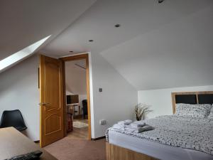 um quarto com uma cama com lençóis brancos e uma janela em Casa Andreea em Vatra Dornei