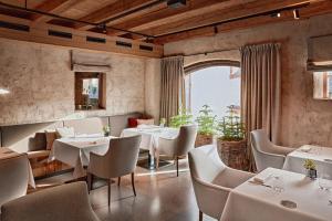 a restaurant with white tables and chairs and a window at Mount Med Resort in Oberau